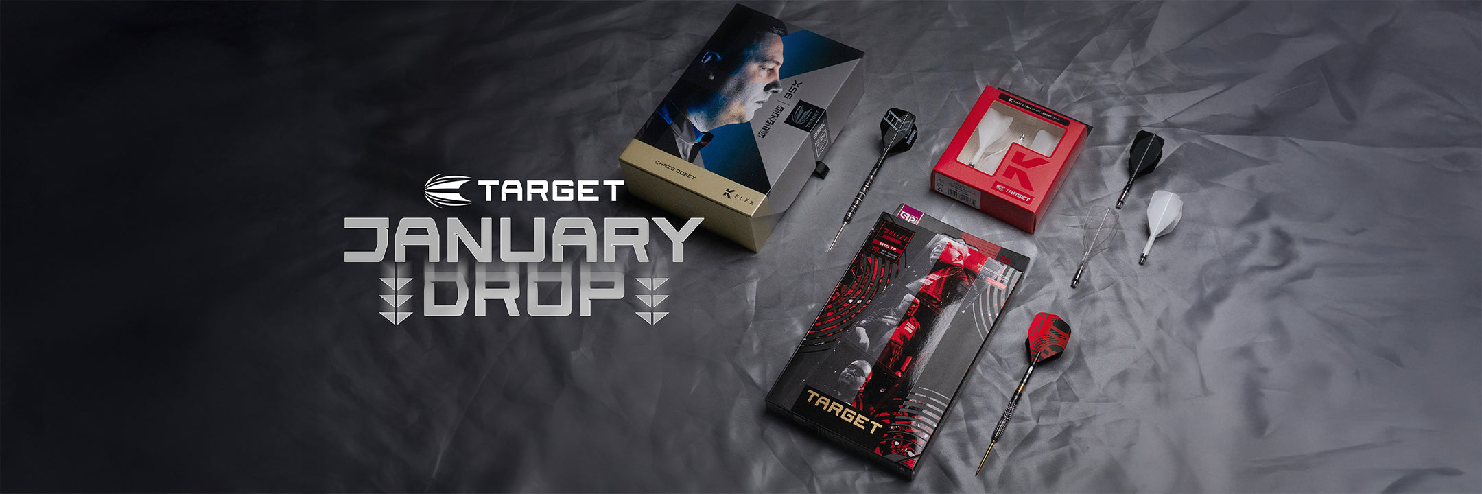 Target darts and packaging with 'January Drop' promotion on a dark surface